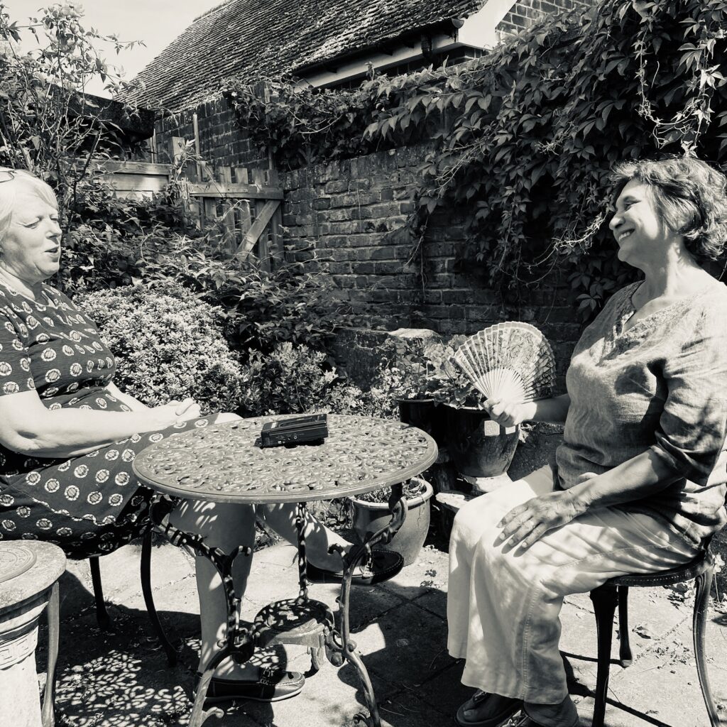 contemporary women being interviewed in the garden socially distanced